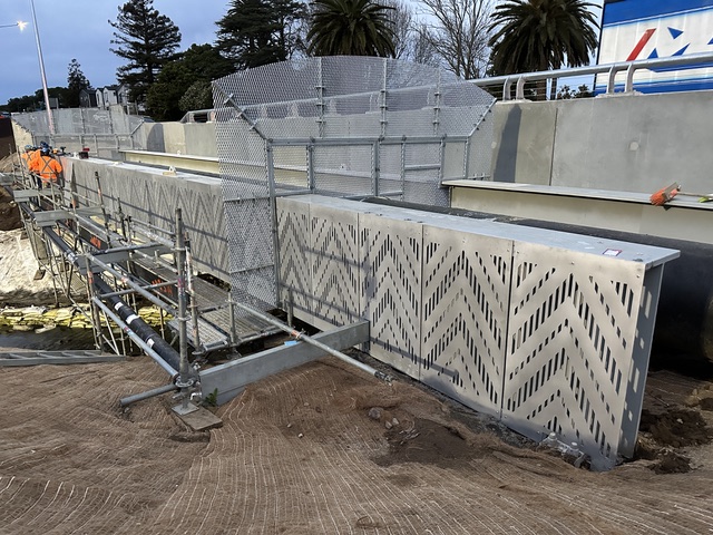 Perforated steel bridge-screen panels with a chevron pattern